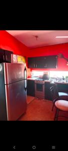 a kitchen with red walls and a stainless steel refrigerator at Departamento Kassandra in Puerto Peñasco