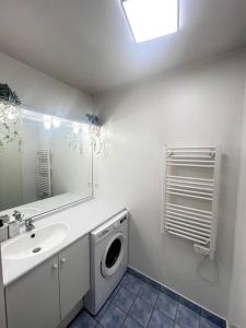 La salle de bains est pourvue d'un lave-linge et d'un lavabo. dans l'établissement Cocon Eudenia - accès direct PARIS - 2 MIN RER - PARKING GRATUIT, à Cergy