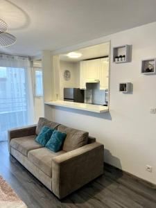 a living room with a couch in a room at Cocon Eudenia - accès direct PARIS - 2 MIN RER - PARKING GRATUIT in Cergy