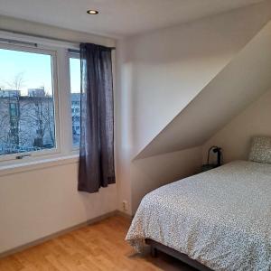 1 dormitorio con cama y ventana grande en The Hui Home en Bergen