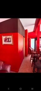 a restaurant with red walls and tables and chairs at Departamento Kassandra in Puerto Peñasco