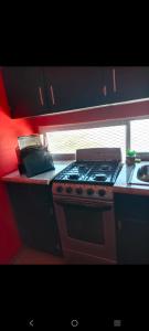 a kitchen counter with a stove and a sink at Departamento Kassandra in Puerto Peñasco
