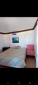 a bedroom with a bed and a red chair at Departamento Kassandra in Puerto Peñasco