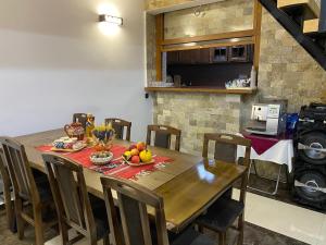 a kitchen with a wooden table with fruit on it at Casa de vacanță Edya in Petroşani