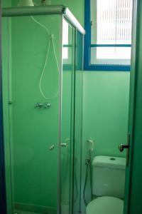 a green bathroom with a shower and a toilet at Acapela Hospedagem in Ouro Preto