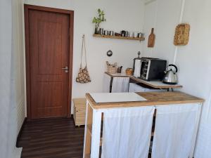 a kitchen with a counter with a microwave and a door at La Estacion Colonia in Colonia del Sacramento