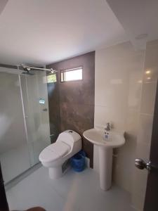 a bathroom with a toilet and a sink and a shower at Hotel Orion in Chinchiná