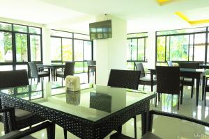 a dining room with tables and chairs and windows at The Room Mahidol Chiangmai in Chiang Mai