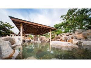 una piscina de agua con un puente y rocas en Kutsurogi no Yado Juraku - Vacation STAY 03507v en Tobe