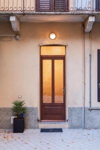 uma porta de madeira na lateral de um edifício em [Como Centro] Proprio dietro l'Angolo em Como