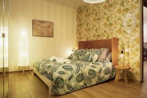 um quarto com uma cama com um edredão e um candeeiro em [Como Centro] Proprio dietro l'Angolo em Como