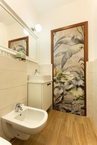 a bathroom with a sink and a toilet and a painting at [Como Centro] Proprio dietro l'Angolo in Como