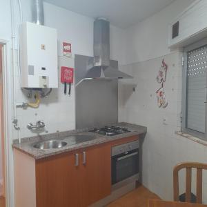 Il comprend une petite cuisine équipée d'un évier et d'une cuisinière. dans l'établissement Brunhedo2, à Vila Boa
