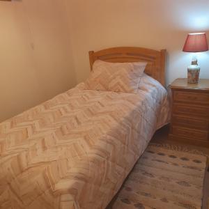 een bed in een slaapkamer met een nachtkastje en een bed sidx sidx sidx sidx bij Brunhedo2 in Vila Boa