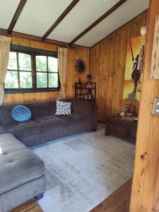 sala de estar con sofá y mesa en Casa o habitacion en carretera austral, en Puerto Montt