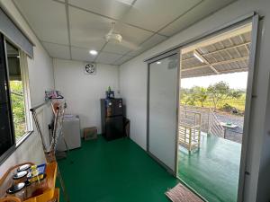 a room with a green floor and a sliding door at Homestay Denai Harummanis S4 in Simpang Empat