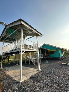 a building with a staircase in front of it at Homestay Denai Harummanis S4 in Simpang Empat