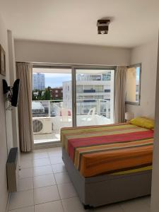 a bedroom with a bed and a large window at Apto 3 dormitorios, Punta del Este parada 2 in Punta del Este