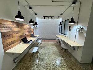 een kamer met 2 bureaus met stoelen en een laptop bij Rustik House in Medellín