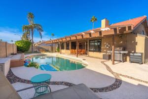 uma casa com piscina em frente a uma casa em Pool, Grill, Outdoor Dining, Fire-pit, Foosball Desert Oasis em Scottsdale