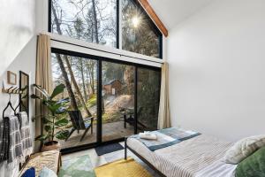 a bedroom with a bed and a large window at Tiny Cabin in RRG - The Naturalist in Rogers
