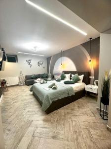 ein Schlafzimmer mit einem großen Bett und einem Sofa in der Unterkunft Stay Inn Central Brasov Ap 3 in Braşov