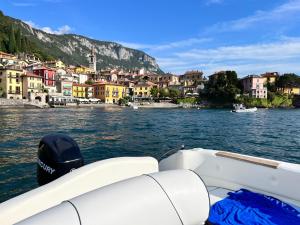 a boat in a body of water with a town at Il terrazzo sul Lago in Varenna
