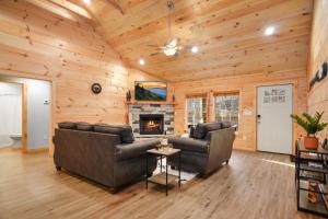 a living room with two couches and a fireplace at Tsaliwood Cabin in Sevierville