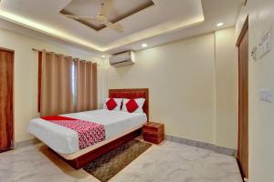 1 dormitorio con 1 cama con manta roja y blanca en OYO Flagship OXY QUEEN PALACE, en Jamshedpur
