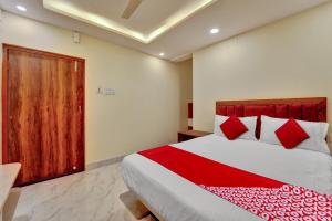 a bedroom with a large bed with red pillows at OYO Flagship OXY QUEEN PALACE in Jamshedpur