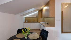 eine Küche mit einem Tisch, Stühlen und einem Waschbecken in der Unterkunft Apartament z WIDOKIEM in Wisła