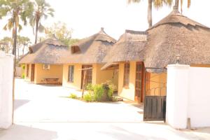 una fila de casas con techos de paja y palmeras en maya bnb, en Nata