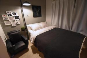 1 dormitorio pequeño con 1 cama y 1 silla en Ethos Ebisu 201 - Vacation STAY 09298v, en Tokio