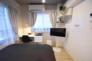 東京にあるEthos Ebisu 201 - Vacation STAY 09298vのベッドルーム1室(ベッド1台、デスク、モニター付)