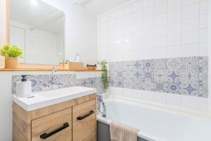 ein Badezimmer mit einem Waschbecken und einer Badewanne in der Unterkunft Le Cosy du grand Stadium Lille in Villeneuve d'Ascq