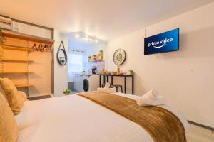 a bedroom with a white bed with a sign on the wall at Le studio du grand Stade de Lille avec parking privé gratuit in Villeneuve d'Ascq