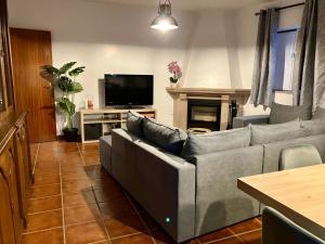 a living room with a couch and a tv at Alojamentos Vila Alpalhão in Alpalhão