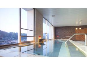高山的住宿－Spa Hotel Alpina Hida Takayama - Vacation STAY 08476v，一座带大窗户的建筑中的游泳池