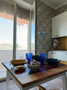 uma cozinha com uma mesa de madeira com tigelas em Mare Azzurro em Torre del Greco