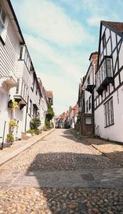 an old cobblestone street in a town with buildings at Rye Harbour Cosy Cottage in Rye