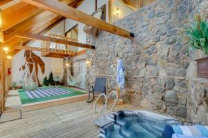 Camera con parete in pietra e vasca da bagno. di Riverside Colorado Chalet with Deck and Hot Tub a Dumont