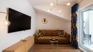 ein Wohnzimmer mit einem Sofa und einem Flachbild-TV in der Unterkunft Apartament z WIDOKIEM in Wisła