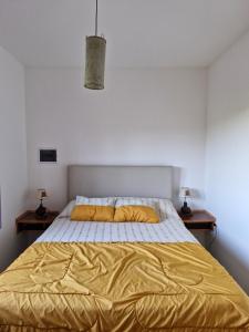 sypialnia z łóżkiem z żółtą pościelą i dwoma stołami w obiekcie Mirador serrano w mieście José de la Quintana