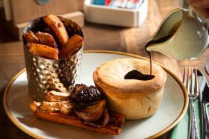a plate of food with a bagel and a cup of bread at The Ullswater Inn- The Inn Collection Group in Glenridding