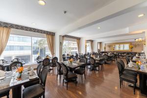 una sala da pranzo con tavoli, sedie e finestre di Hotel Jose Antonio a Lima
