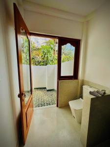 una puerta abierta a un baño con aseo en Swallow villa - French guest house en Ahangama