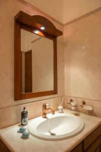 a bathroom sink with a mirror and a sink at Villa Carilù in Altavilla Milicia