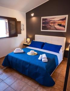 a bedroom with a blue bed with towels on it at Villa Carilù in Altavilla Milicia