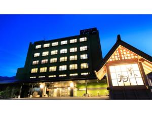 duży budynek z oświetlonymi oknami przed nim w obiekcie Ryokan Biyu no Yado - Vacation STAY 16236v w mieście Yokokura