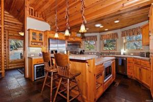 una gran cocina con armarios de madera y una isla central en Peaceful Cabin Home with Breathtaking View!, en Big Bear City